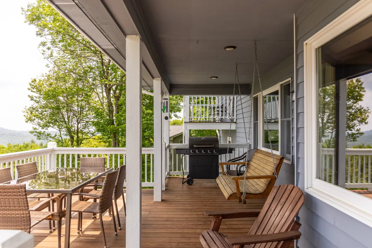 An outdoor dining area is shown, complete with a table, grill, swing bench, and lush greenery all around. The inviting layout is ideal for shared meals, barbecues, and relaxed group gatherings, capturing the joy of communal outdoor experiences.